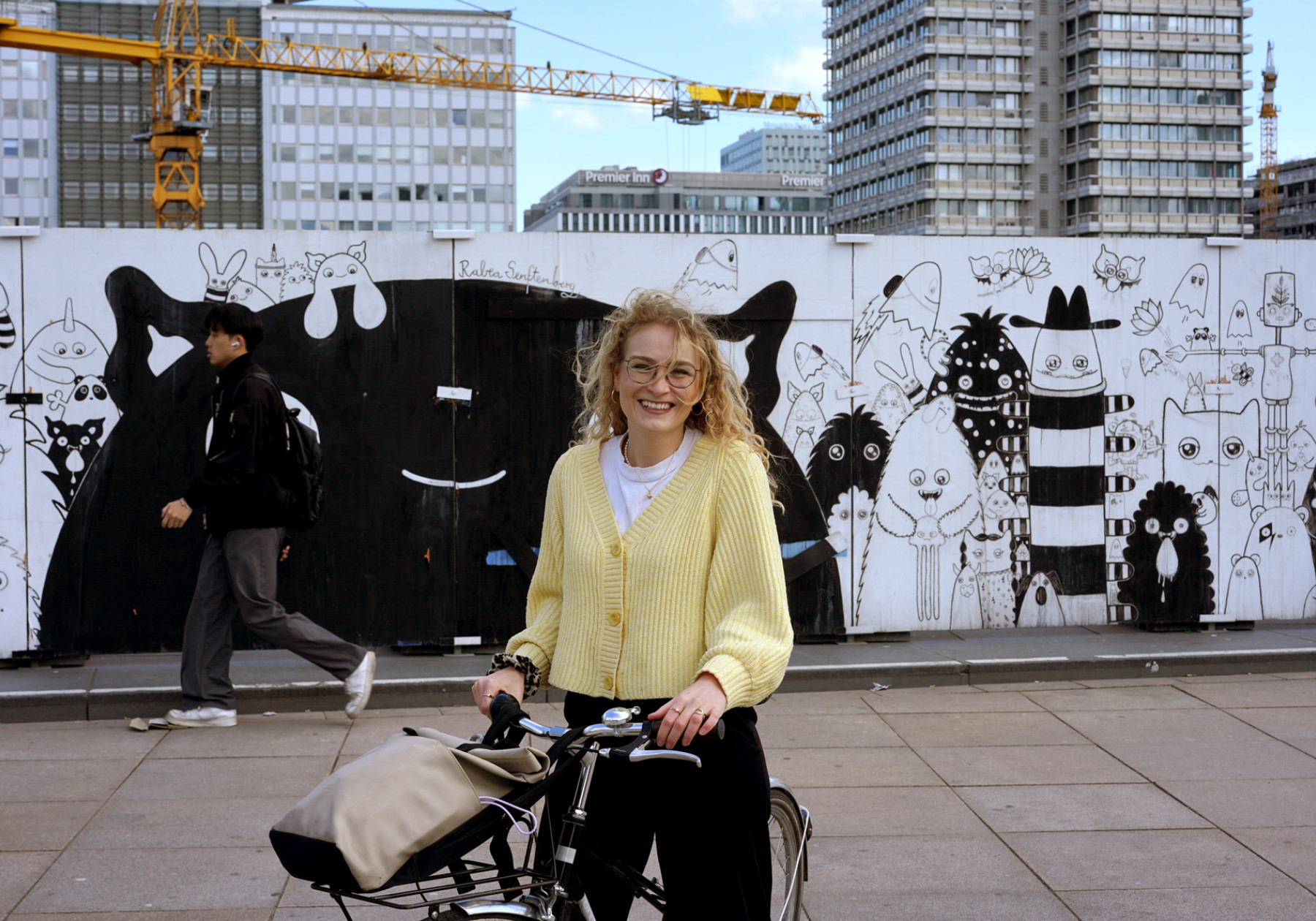 a smiling woman with standing by her bike
