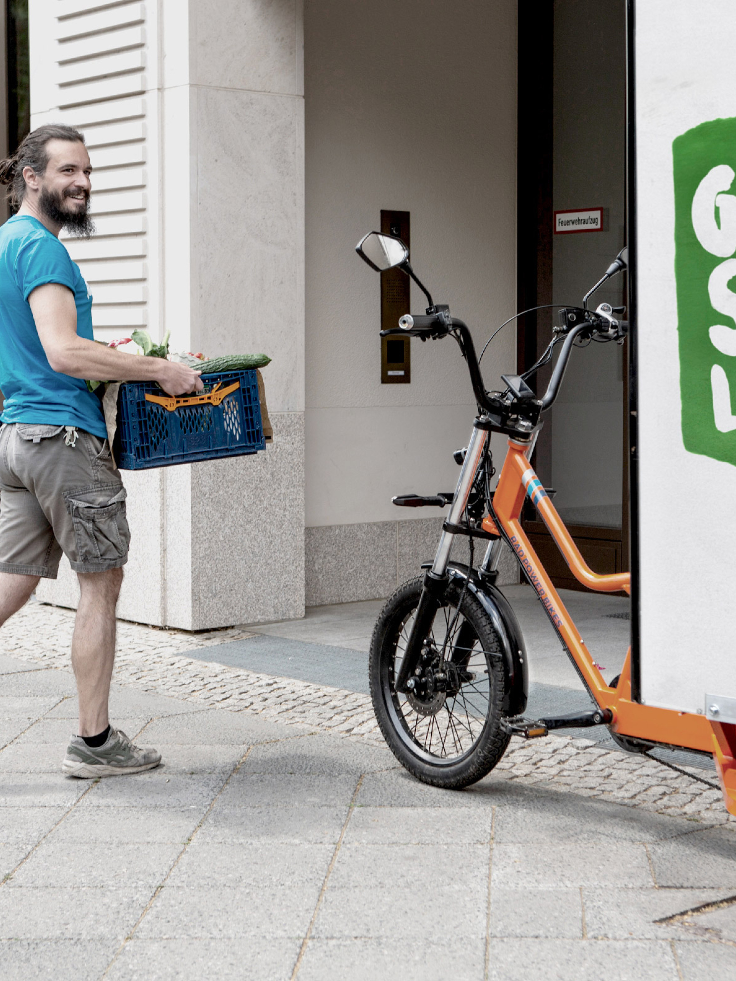 Lieferant und Cargobike mit der Aufschrift "Grüne Stadtlogistik"