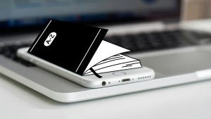 Aus Bildschirm von Handy kommen Seiten eines Lexikons