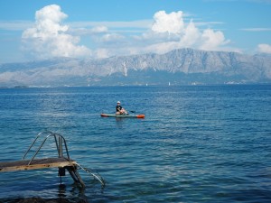 Celina Müller auf einem SUP im See, mit den Bergen im Hintergrund