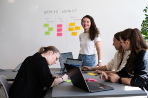 Celina Müller gibt einen Workshop und steht im Hintergrund, im Vordergrund sitzen Kolleginnen an Laptops