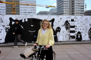 a smiling woman with standing by her bike