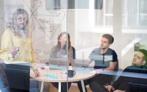 A female person in front of a team leading a workshop