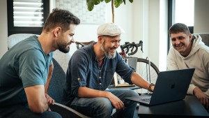 Jacob Klimes, Lead Consultant bei Exxeta, mit zwei Kollegen gemeinsam am Laptop