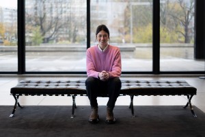 Eine Frau sitzt auf einer Bank und lächelt