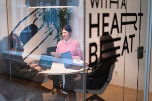 Mehrere Personen sitzen mit Laptops an einem Tisch