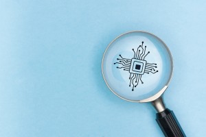Eine Lupe vergrößert ein Chip-Symbol mit Leiterbahnen auf blauem Hintergrund als Symbol für die Analyse von KI-Modellen und Technologie.