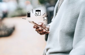 Person mit einem Smartphone in der Hand und Illustrationen für Batterie, Kalender und Favoriten